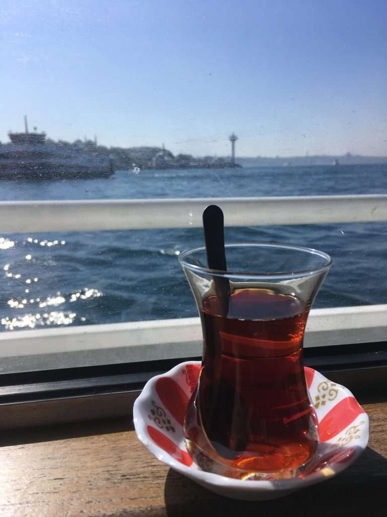 A cup of turkish tea by the window of the ferry in Istanbul