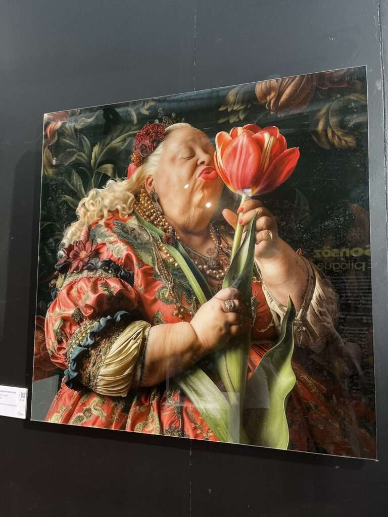 Painting of a joyous woman in opulent Renaissance attire, passionately smelling a large red tulip, capturing a moment of bliss and splendor on canvas. Taken at the Tulipomania Exhibit at the Istanbul Tulip Museum in Emirgan in April 2024.