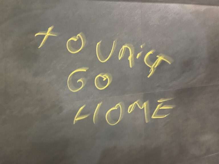 Yellow graffiti written on a grey stone wall saying "Tourist go home" in response to overtourism in Bilbao, Spain, seen in June 2024. Responsible tourism tips and practices are a way for visitors to be mindful of the places they visit.