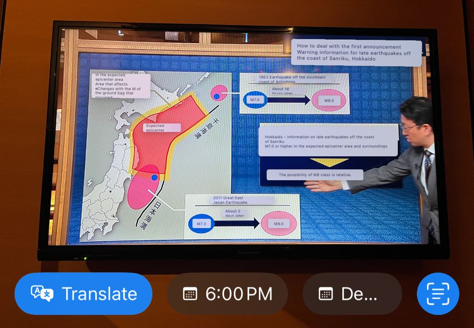 Japanese news of the 7.6 magnitude Hokkaido earthquake in December 2025. The weatherman points to areas that were affected and the overlaid text has been Google translated into English through my phone's camera, using the offline language pack for Japanese.