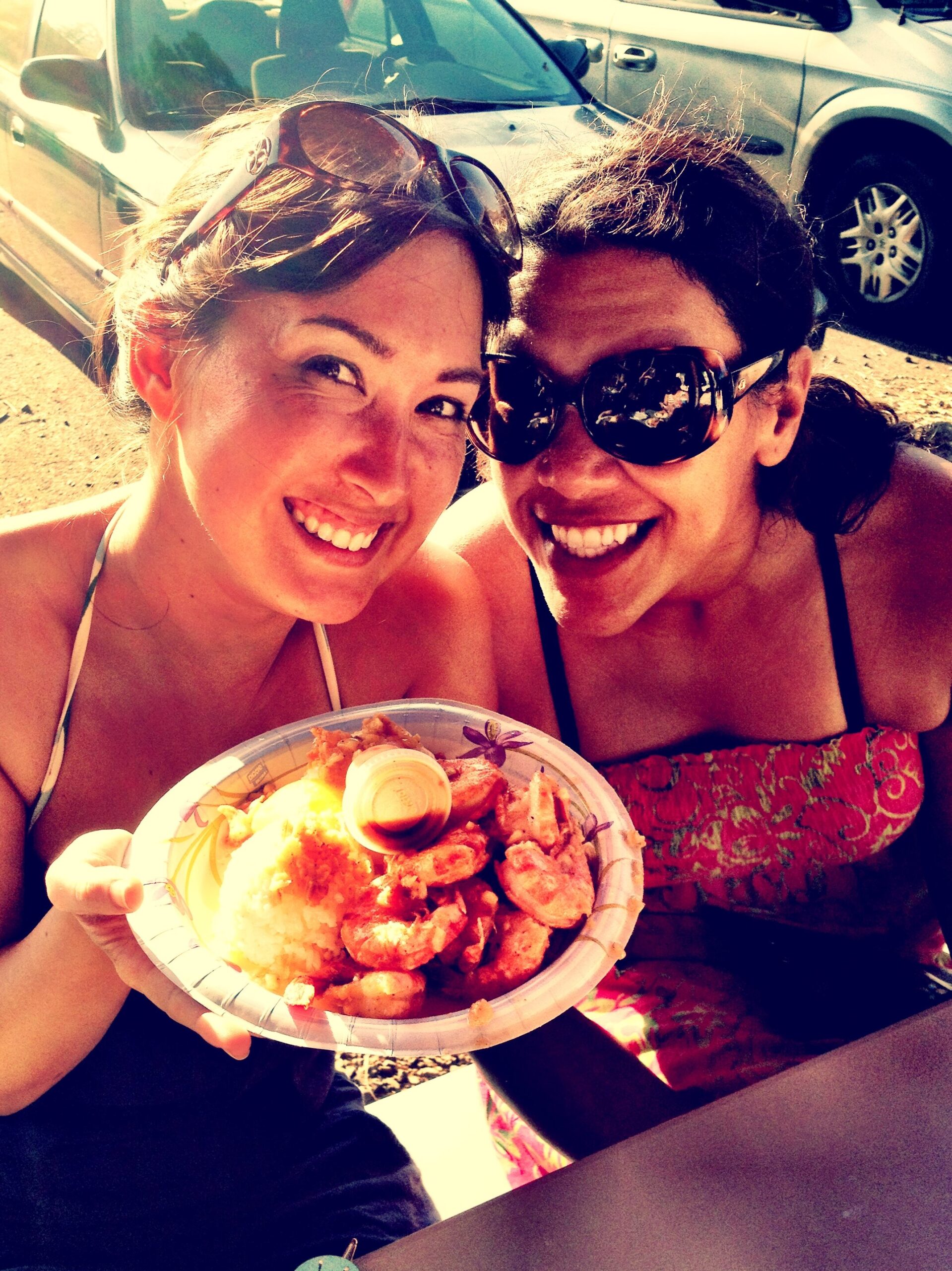 Author Malia Yoshioka and friend holding up a plate of garlic shrimp from Giovanni's White Shrimp Truck in Kahuku on the North Shore of Oahu. A dozen huge shrimp wok-fried with heaps of garlic, servied with two scoops of rice, a lemon wedge and a side of Giovanni's special hot sauce. It is my favorite reason to take a North Shore road trip from Honolulu!